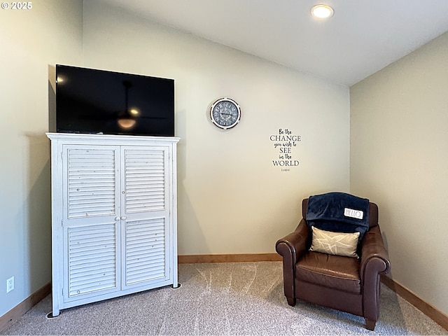 sitting room with carpet flooring, baseboards, and vaulted ceiling