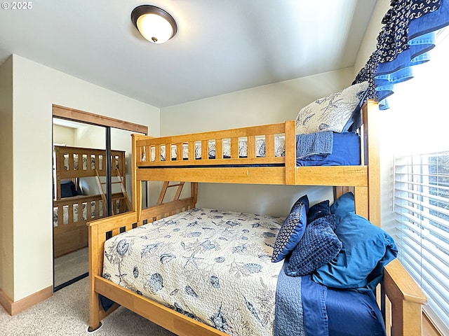 carpeted bedroom with a closet and baseboards