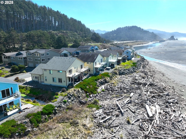 aerial view featuring a residential view, a beach view, and a water and mountain view