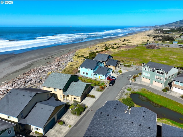 drone / aerial view with a residential view, a water view, and a beach view