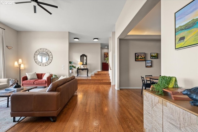 living area featuring ceiling fan, wood finished floors, and baseboards