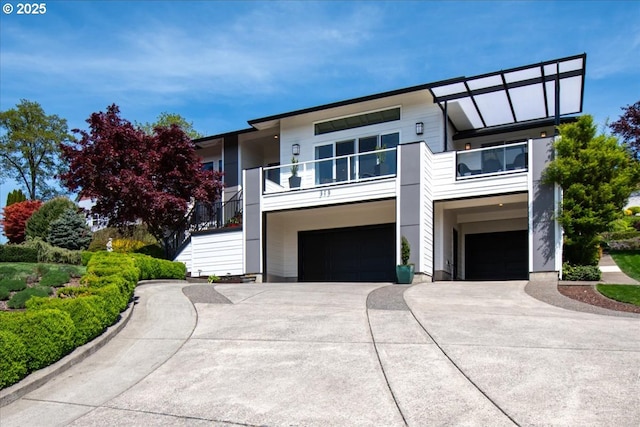 view of front of home featuring a balcony, concrete driveway, and an attached garage
