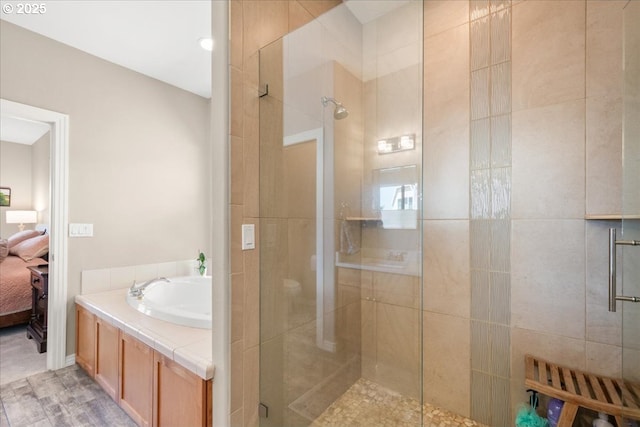 ensuite bathroom featuring connected bathroom, a shower stall, and a sink