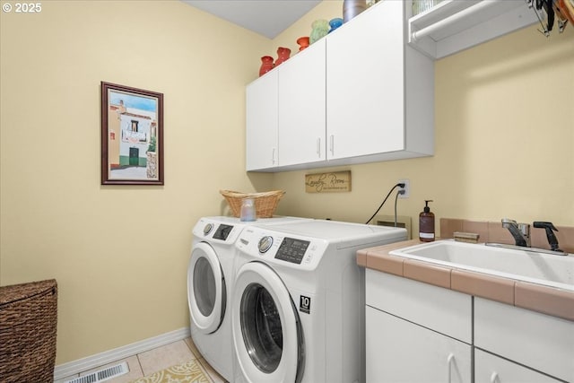 laundry area with light tile patterned floors, washing machine and clothes dryer, visible vents, baseboards, and cabinet space