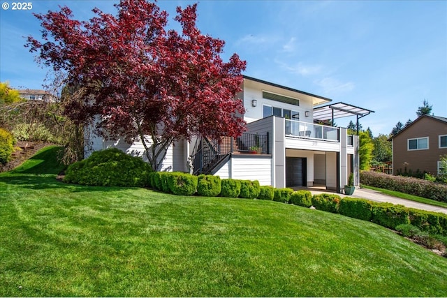 view of front of house with driveway, a front yard, stairs, and a balcony