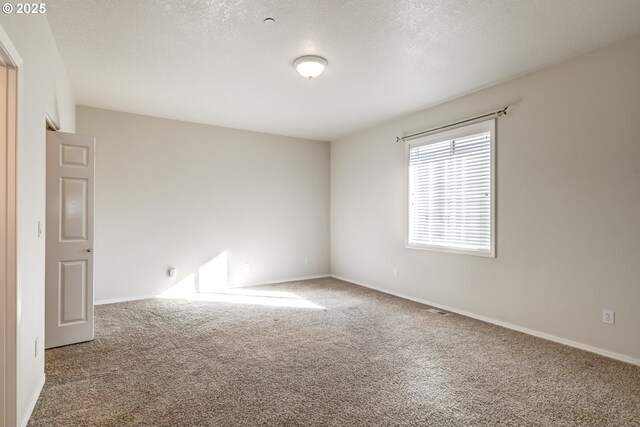 unfurnished bedroom featuring baseboards, ensuite bathroom, carpet, a spacious closet, and a closet