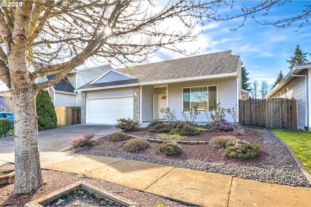 ranch-style home with a shingled roof, concrete driveway, an attached garage, and fence