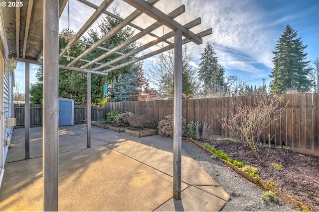 view of patio featuring an outbuilding, a storage unit, a fenced backyard, and a pergola