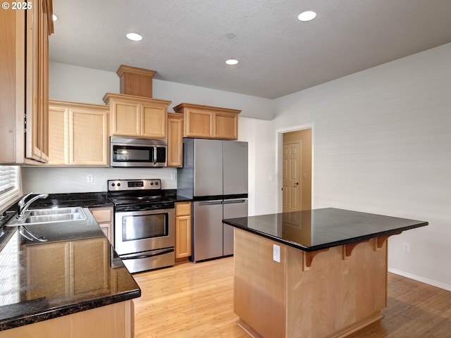 2532 Bryce Ave, Forest Grove, OR 97116 - kitchen with a kitchen breakfast bar, light brown cabinets, light wood-type flooring, appliances with stainless steel finishes, and a sink