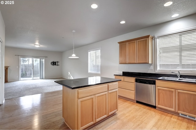 kitchen with open floor plan, light brown cabinetry, light wood-type flooring, stainless steel dishwasher, and a sink