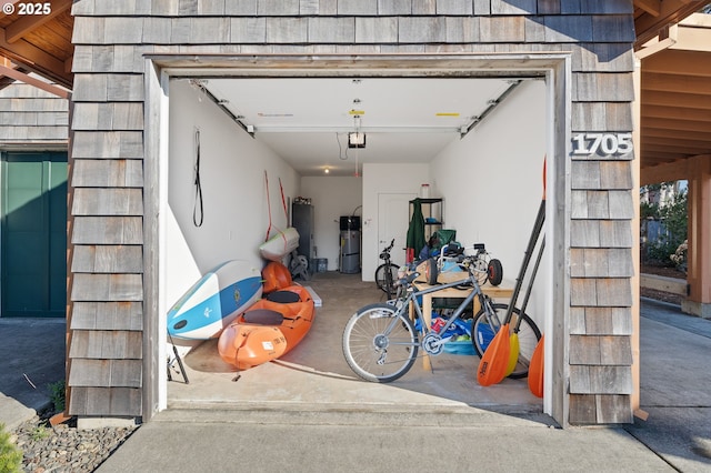 garage featuring water heater, a garage door opener, and strapped water heater