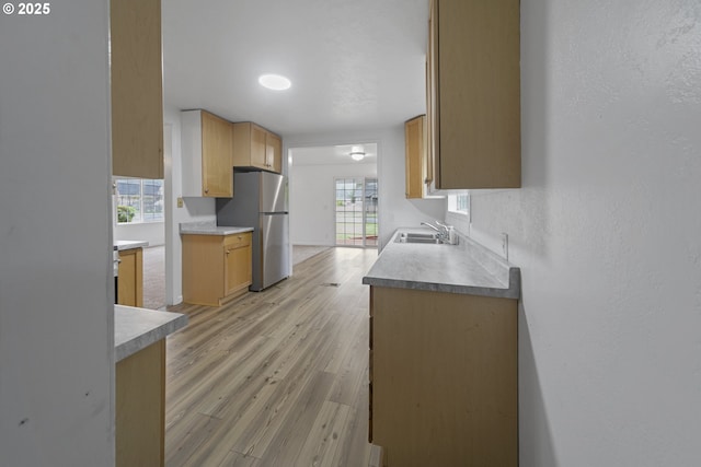 276 S 21st St, Reedsport, OR 97467 - kitchen featuring freestanding refrigerator, a sink, light wood finished floors, and a textured wall