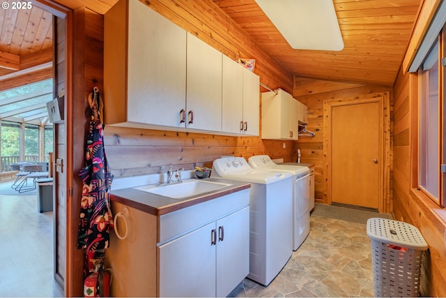 washroom with sink, wooden walls, cabinets, washer and dryer, and wooden ceiling