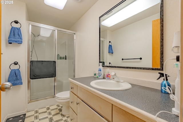 bathroom with a shower with door, vanity, and toilet