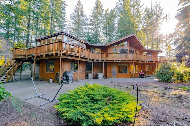 rear view of property featuring a deck and a patio area