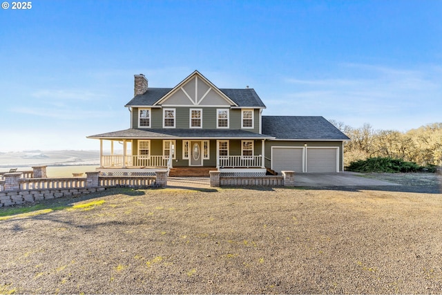 view of front of house with a garage, a front lawn, and covered porch