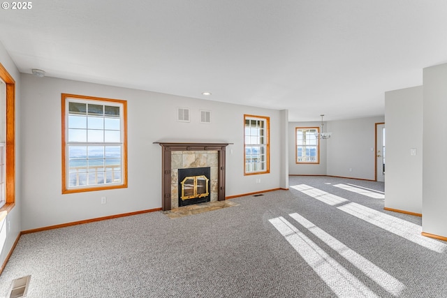 unfurnished living room featuring carpet flooring and a tile fireplace