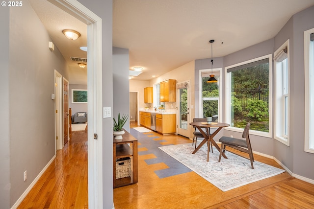 interior space with light wood-type flooring, visible vents, and baseboards