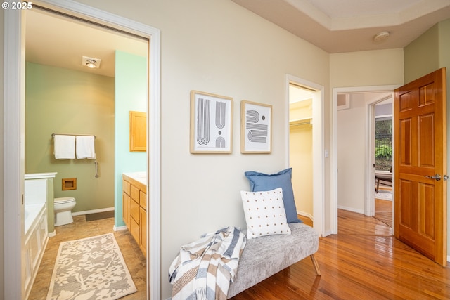 interior space featuring toilet, wood finished floors, vanity, and baseboards