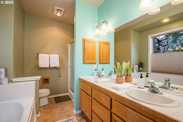 full bath with toilet, double vanity, and a sink