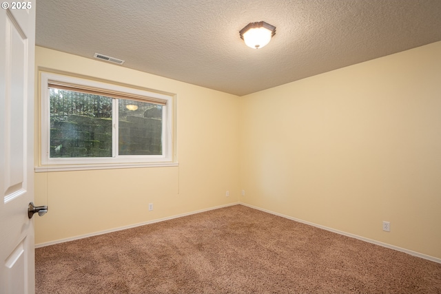 carpeted empty room with a textured ceiling, visible vents, and baseboards