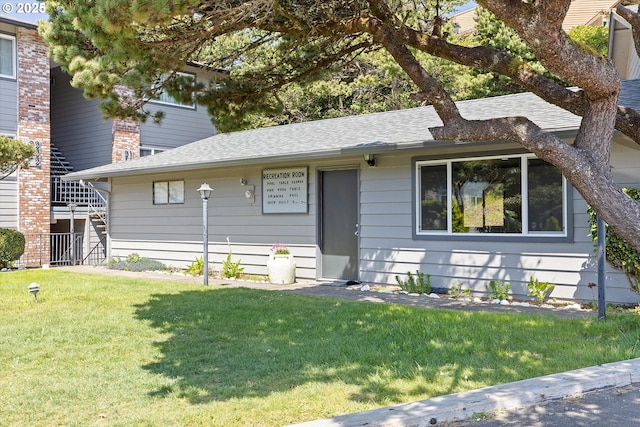 4229 SW Beach Ave Unit 27, Lincoln City, OR 97367 - view of front of home with a shingled roof and a front yard