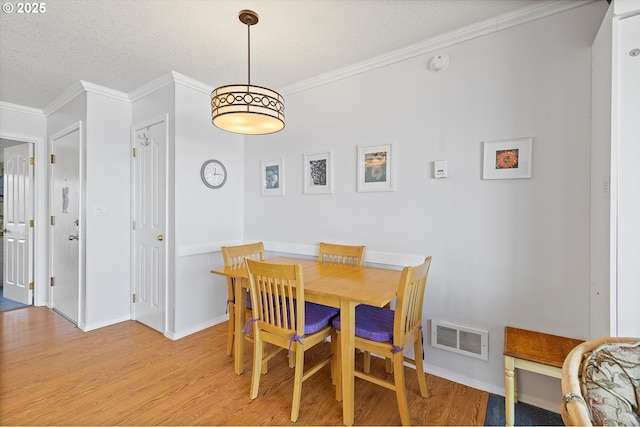 4229 SW Beach Ave Unit 27, Lincoln City, OR 97367 - dining room featuring baseboards, visible vents, ornamental molding, and light wood-style floors