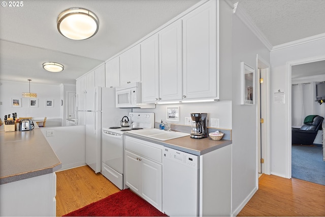 4229 SW Beach Ave Unit 27, Lincoln City, OR 97367 - kitchen featuring crown molding, white appliances, white cabinets, a sink, and light wood-style flooring