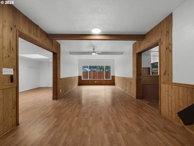 unfurnished room with wainscoting, wood walls, and wood finished floors