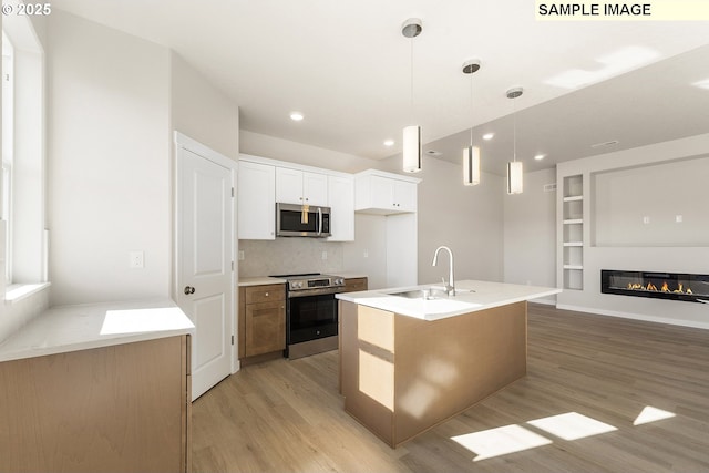 1201 NE Emerald Dr, Hermiston, OR 97838 - kitchen with stainless steel appliances, light wood-style flooring, backsplash, decorative light fixtures, and light countertops