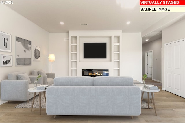1201 NE Emerald Dr, Hermiston, OR 97838 - living room featuring light wood-style floors, recessed lighting, a glass covered fireplace, and built in shelves