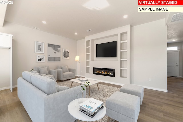 1201 NE Emerald Dr, Hermiston, OR 97838 - living area featuring wood finished floors, built in features, recessed lighting, and a glass covered fireplace