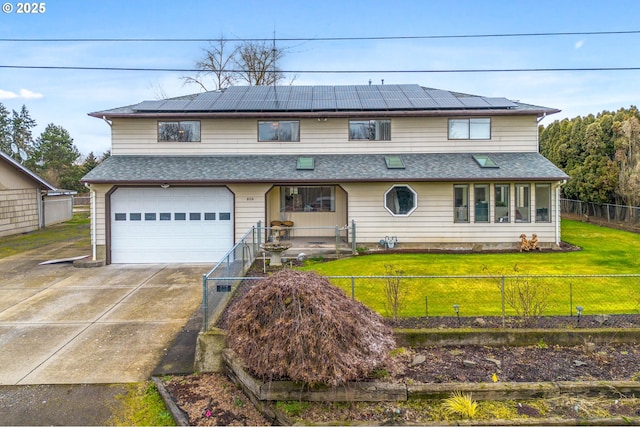 view of front of home with a garage, a front lawn, and solar panels