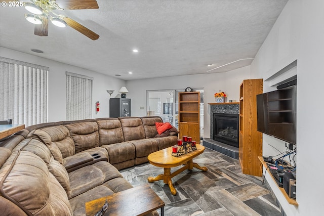 living room with ceiling fan and a textured ceiling