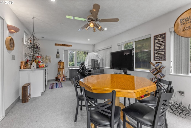 carpeted dining area with ceiling fan