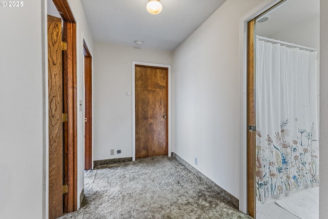 hall with carpet and a textured ceiling