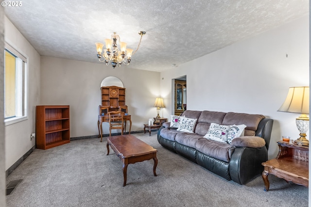 living room featuring a textured ceiling, carpet floors, and a chandelier