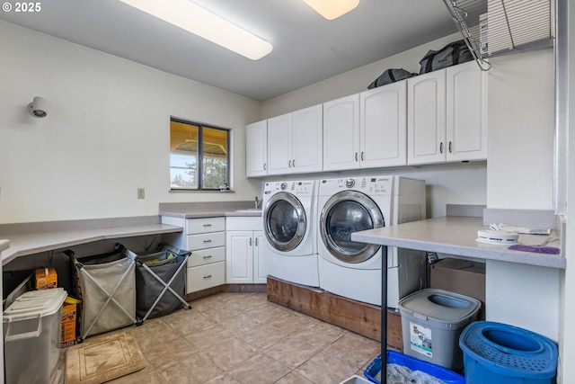 laundry room with cabinets, washer and clothes dryer, and sink