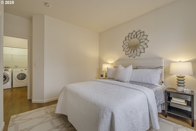 bedroom with separate washer and dryer and hardwood / wood-style flooring