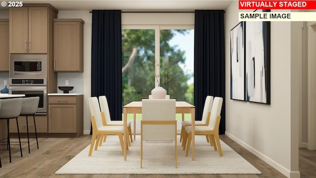 dining area with light wood finished floors and baseboards