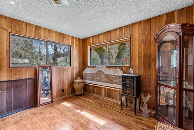 725 Rogue River Hwy, Gold Hill, OR 97525 - living area featuring baseboards, a textured ceiling, wood finished floors, and wooden walls