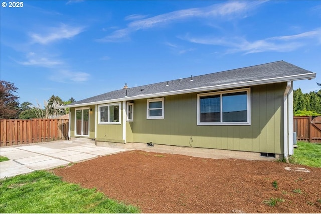 rear view of property with crawl space, a patio area, a fenced backyard, and roof with shingles