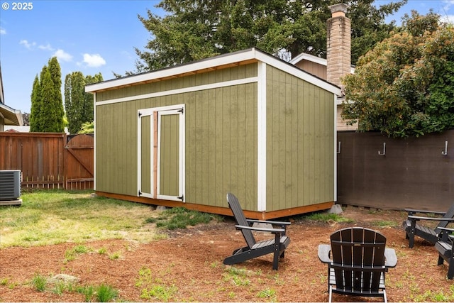 view of shed featuring fence, central AC, and a gate