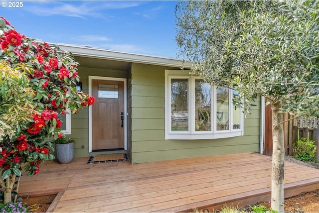 entrance to property with a wooden deck and fence