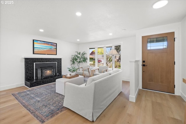 living area with light wood-style floors, baseboards, and recessed lighting