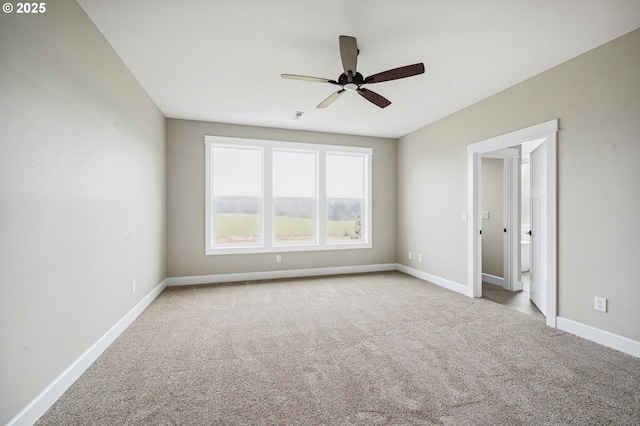 carpeted spare room with ceiling fan