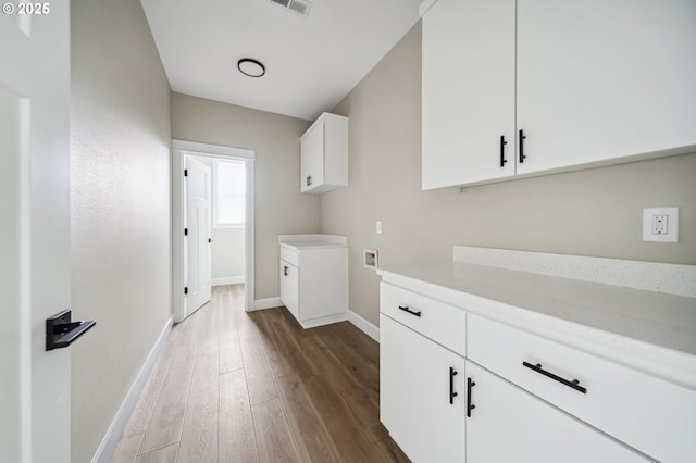 washroom featuring cabinets, hookup for a washing machine, and dark wood-type flooring