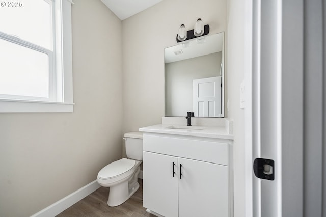 bathroom featuring vanity, hardwood / wood-style floors, and toilet