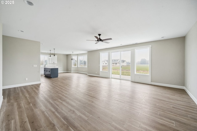 unfurnished living room featuring light hardwood / wood-style flooring and ceiling fan