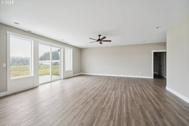 empty room with hardwood / wood-style floors and ceiling fan